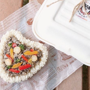 A heart-shaped meat-filled cake suitable for both cats and dogs with a paper container on the side
