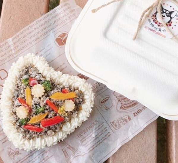 A heart-shaped meat-filled cake suitable for both cats and dogs with a paper container on the side